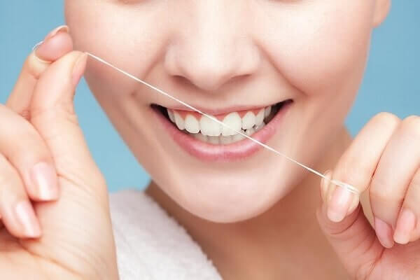 Cách dùng chỉ nha khoa để làm sạch, loại bỏ thức ăn thừa dính trên răng, ngăn chặn hình thành mảng bám trên răng hiệu quả
