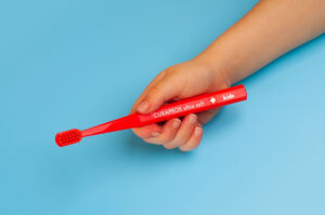 Bàn chải trẻ em màu đỏ có tay cầm